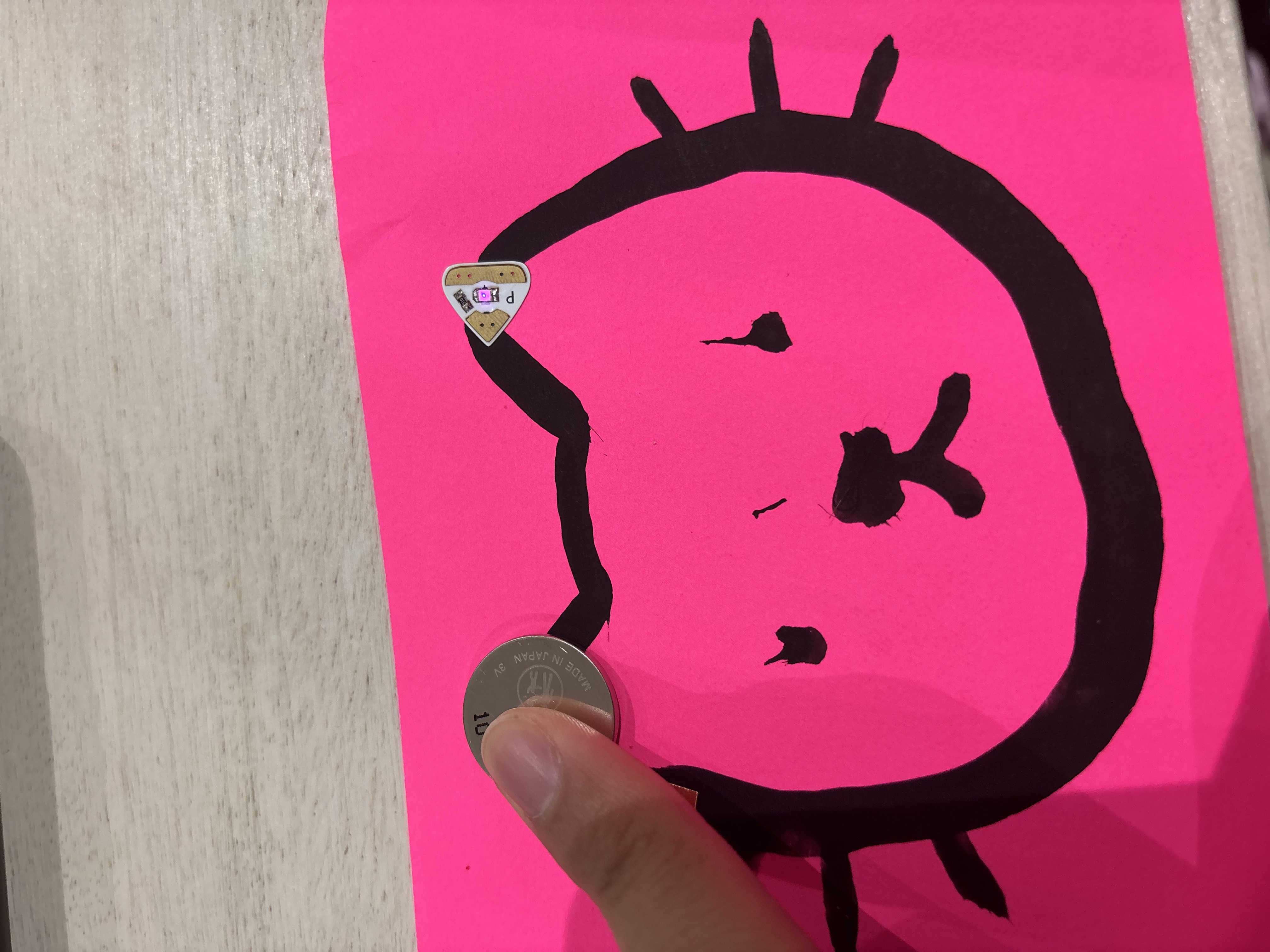 Paint circuit with conductive paint, a battery, and a light bulb.