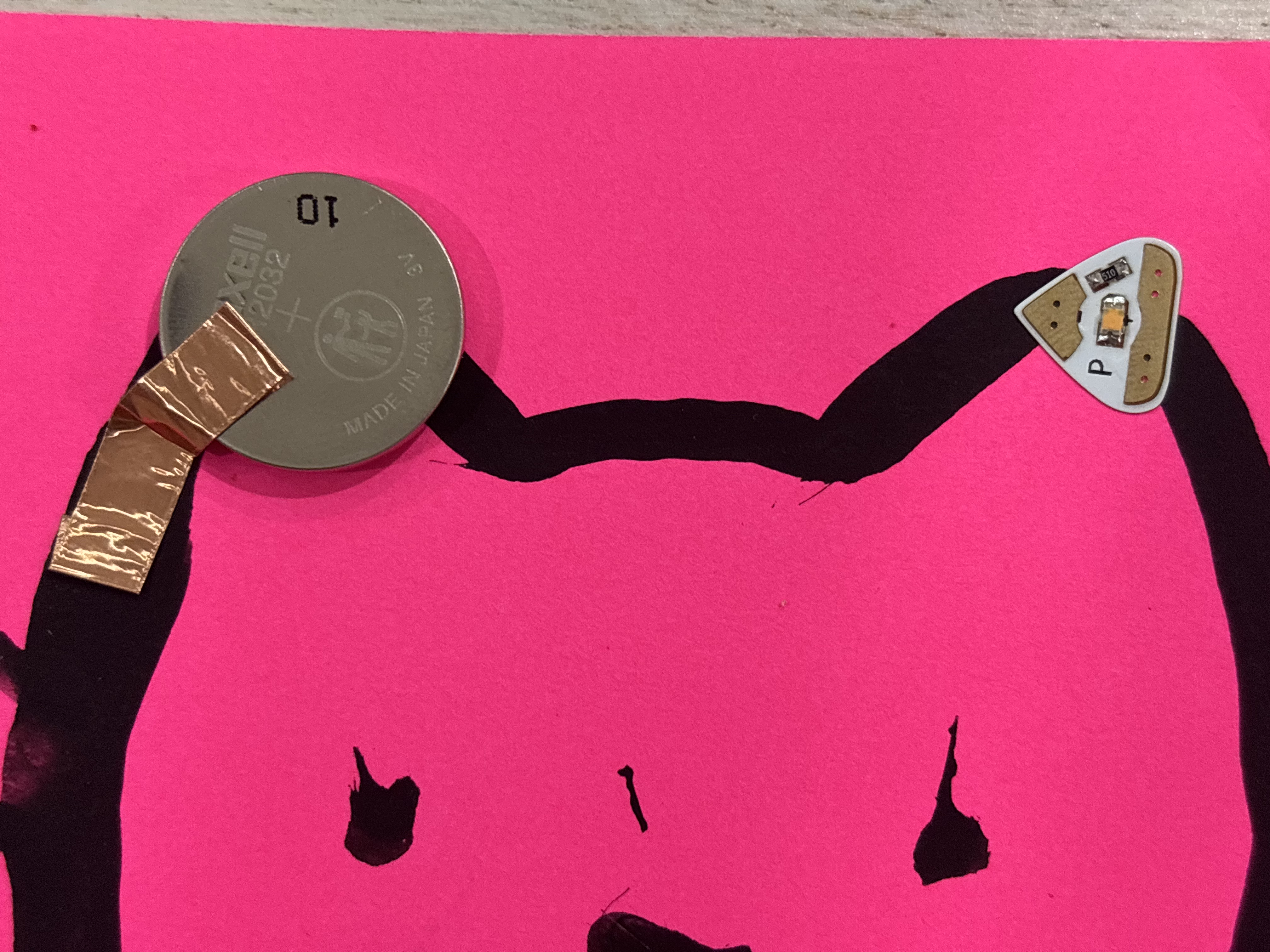 Paint circuit with conductive paint, a battery, and a light bulb.
