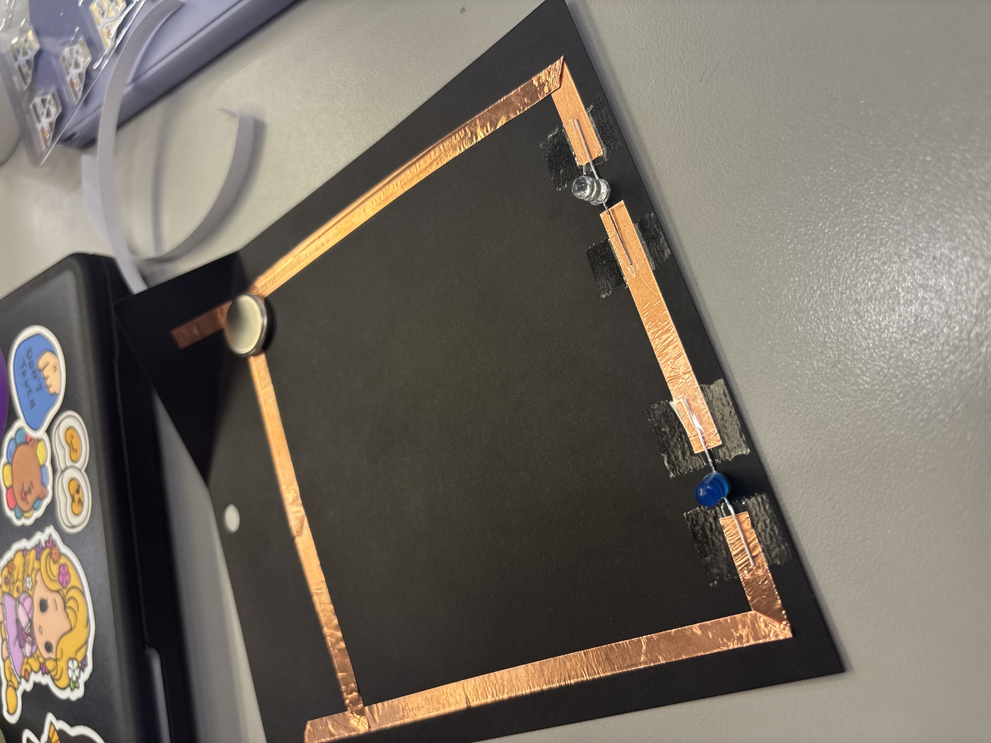 Second paper circuit using copper tape, a battery, and three light bulbs.